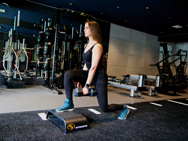 A front foot elevated split squat being performed as an example of a unilateral exercise vs bilateral.